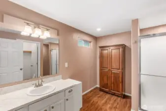 The primary bathroom with linen cabinet, walk in closet and step in shower.