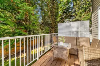 Private deck off the kitchen/dining room that looks out at a nice green space.