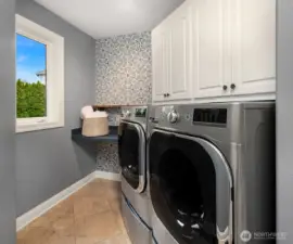 Main level laundry room with cabinets, counter space and storage closet