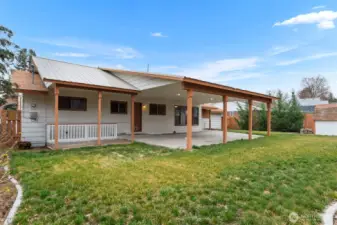 Back yard space and exterior entrance to basement on the left side of home.