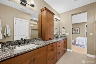 Primary bath: Quartz counters, undermount sinks, beautiful cabinetry, and tiled flooring.